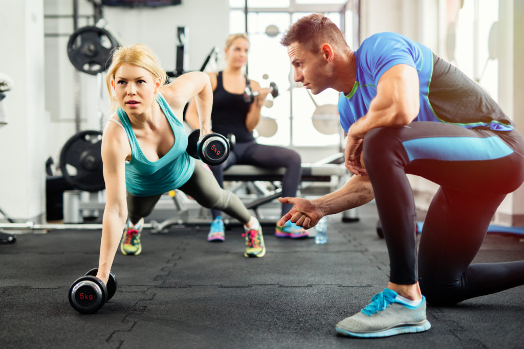 Personal trainer helping client