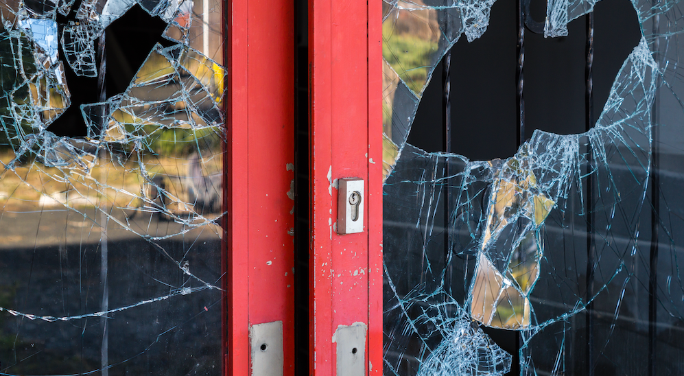 Red business door with broken glass.