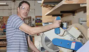carpenter using a saw about to cut a piece of wood