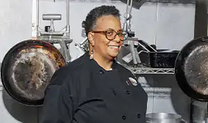 caterer standing in front of pots and pans