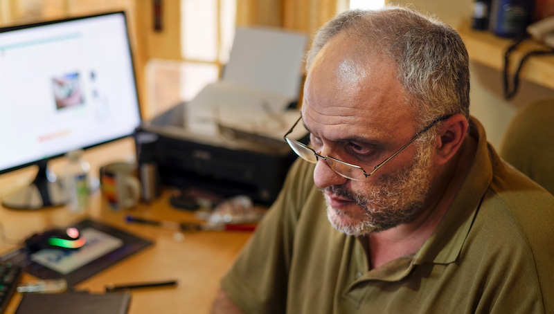 Professional worker looks away from their computer with a worried facial expression