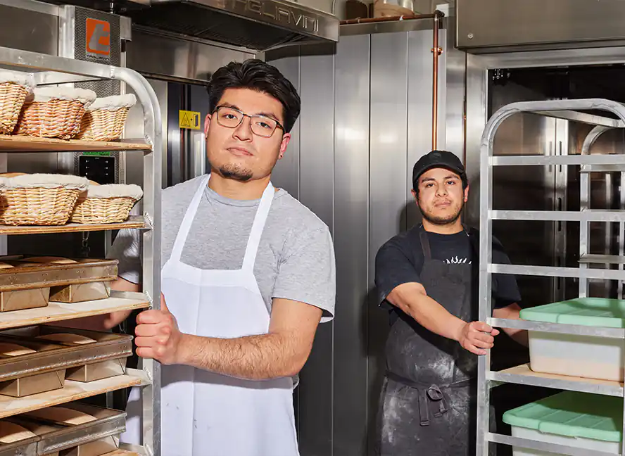bakers pushing racks of bread