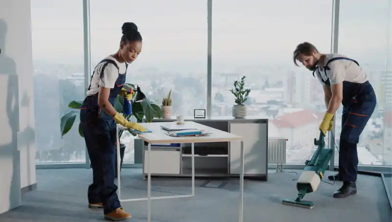 Two people cleaning an office